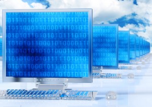 Abstract photo of keyboards and monitors lined up with blue screens and numbers on them and clouds in the background