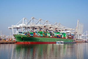 Green ship in the water with shipping containers on it