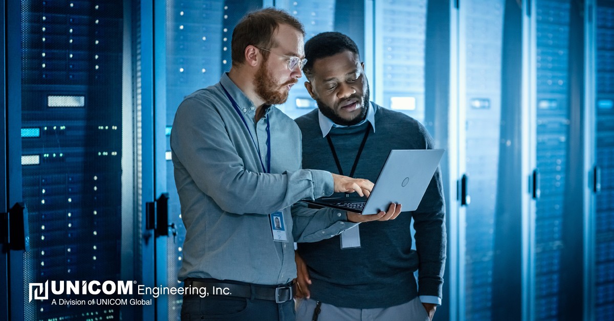Two men in data storage center working on laptop