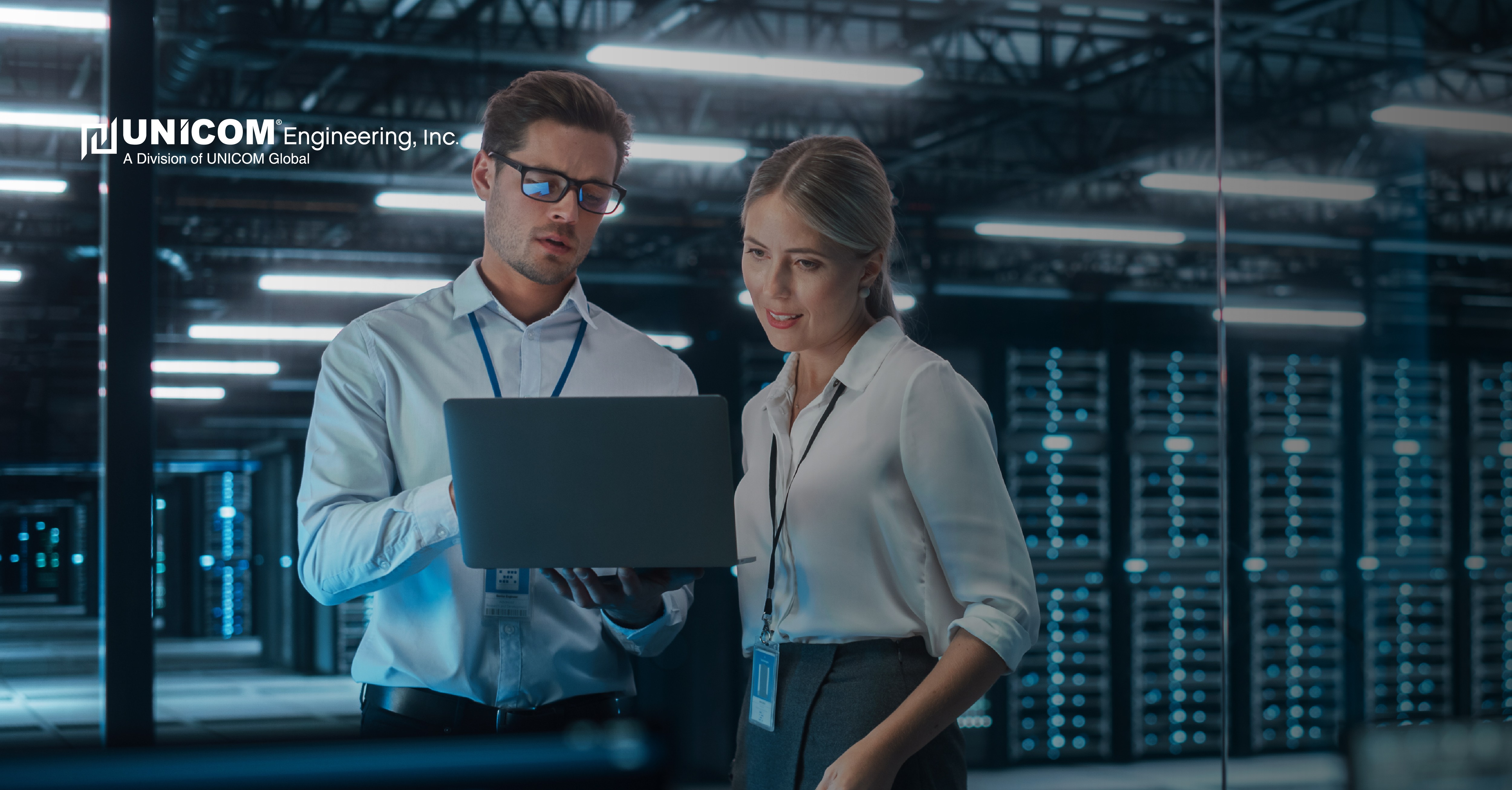 Two men in data storage center working on laptop