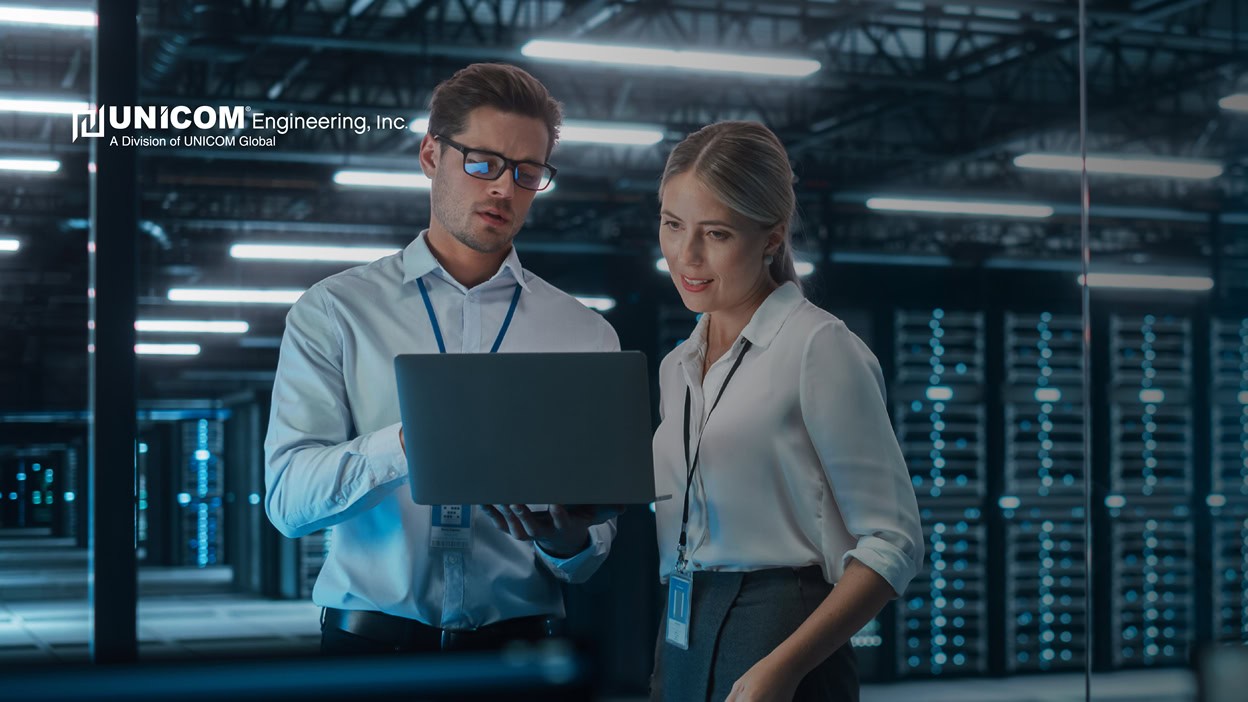 Two men in data storage center working on laptop